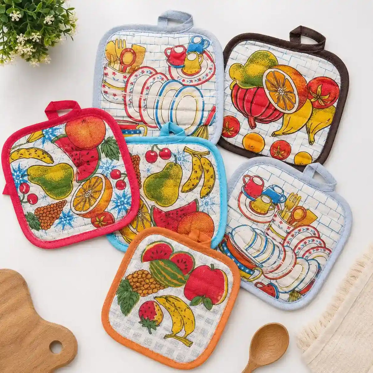 Premium quilted cotton kitchen pot holder with colorful fruit print used for safely handling hot cookware.