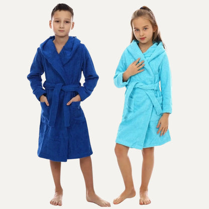Two children modeling plush bathrobes against a plain light background. The boy wears a royal blue robe, and the girl wears a light aqua blue robe.